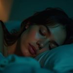 A young adult sleeping in a soft teal-lit bedroom, illuminated by the warm glow of a nearby sleep tracker, highlighting sensitivity to nighttime ambiance.