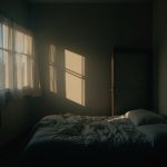 A shadow-filled bedroom with uneven walls, messy bed, and fragmented lighting, highlighting an uneasy and disrupted sleep environment.