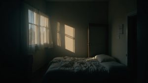 A shadow-filled bedroom with uneven walls, messy bed, and fragmented lighting, highlighting an uneasy and disrupted sleep environment.